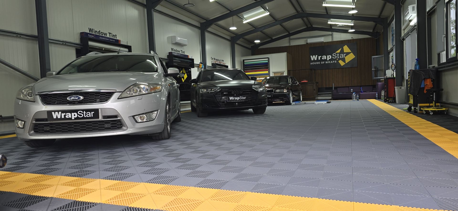 Atelier folii auto Craiova, mai multe mașini pregătite pentru foliere